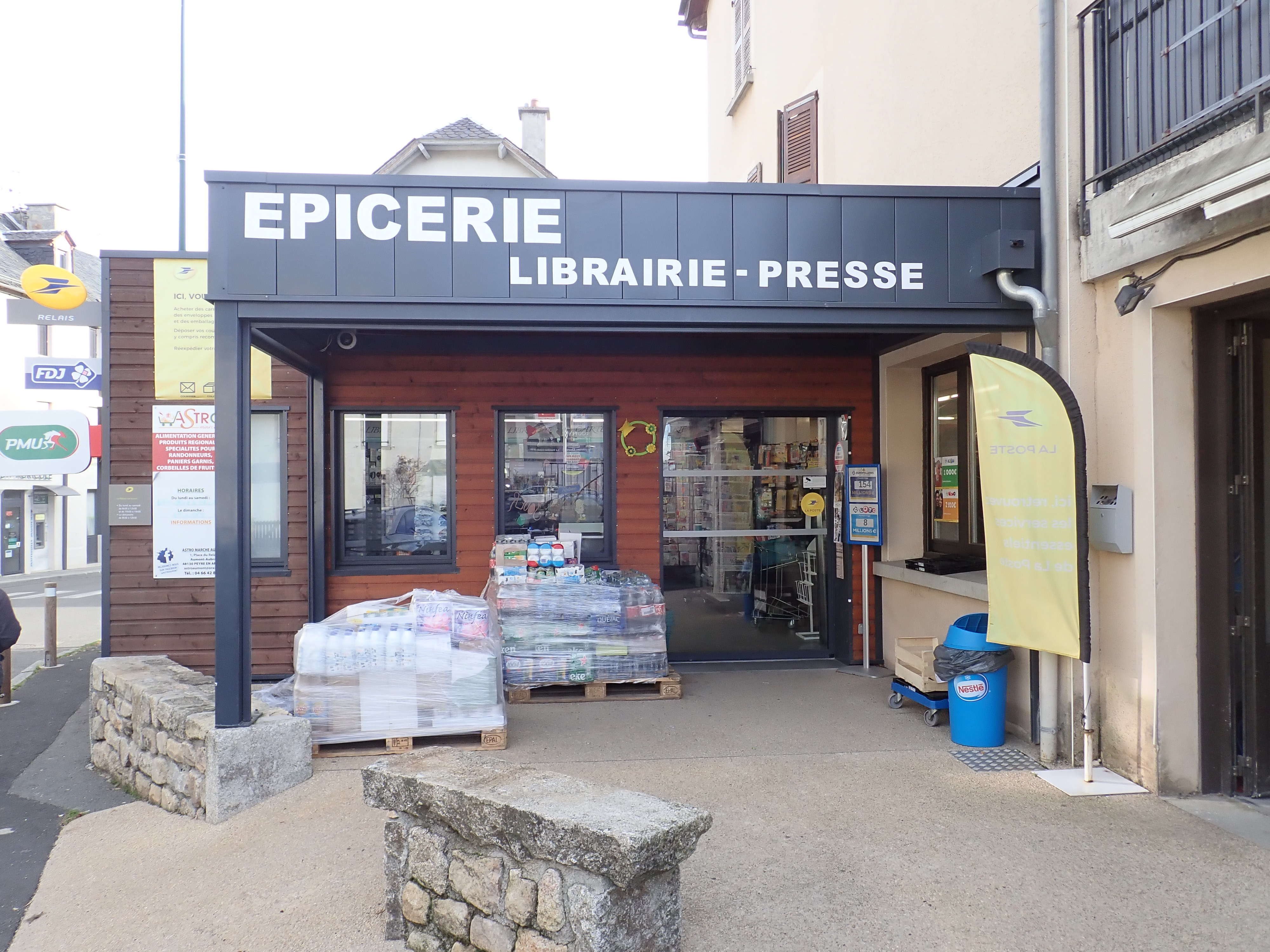 devanture d’une épicerie de village française avec des produits en rayon, vitrine visible depuis la rue