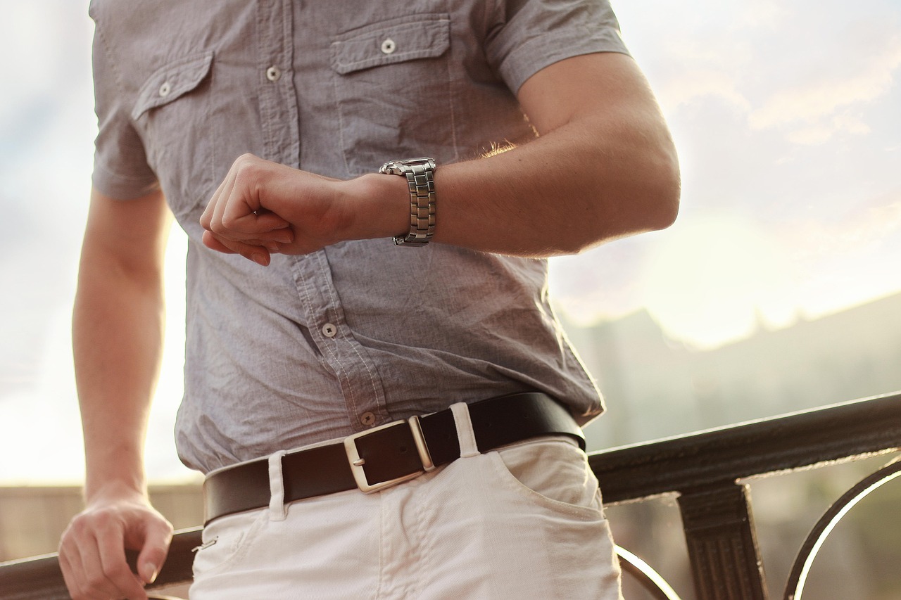 main d'un homme consultant sa montre en prenant une note, écriture manuscrite