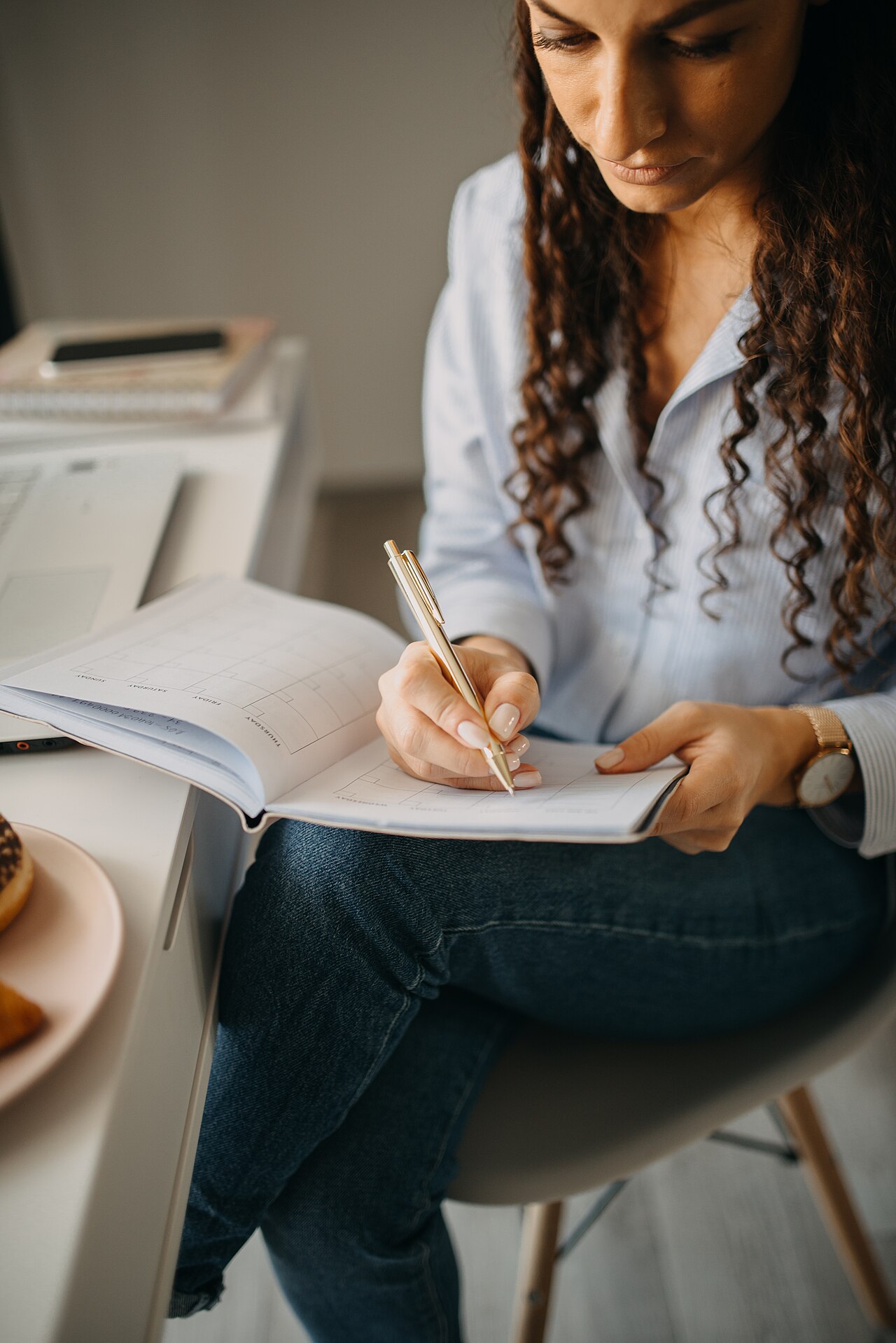 jeune femme qui relit ses notes et étudie à son bureau avec un cahier ouvert