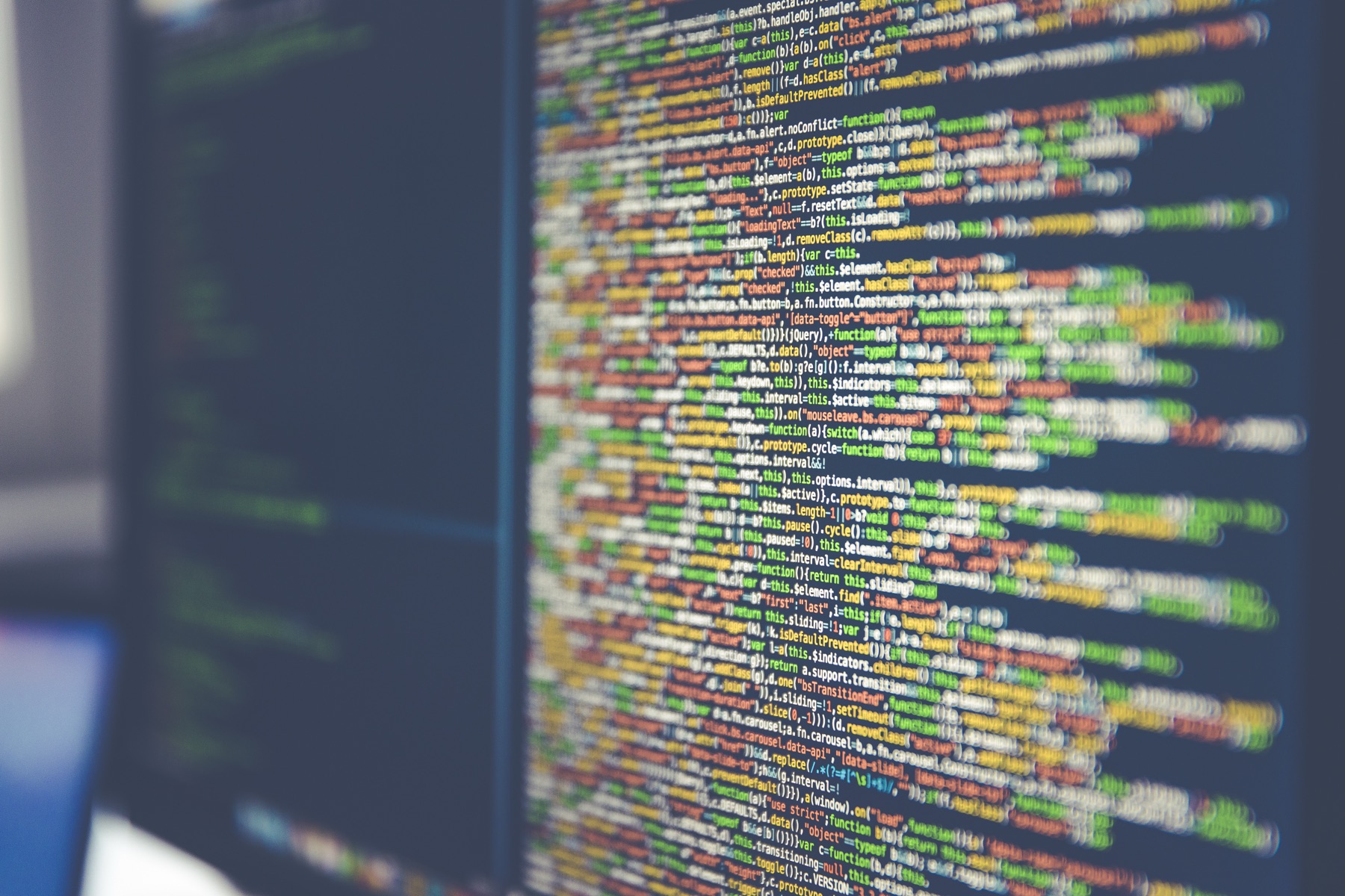 code source affiché en plein écran sur un moniteur d'ordinateur, lignes colorées de HTML et CSS