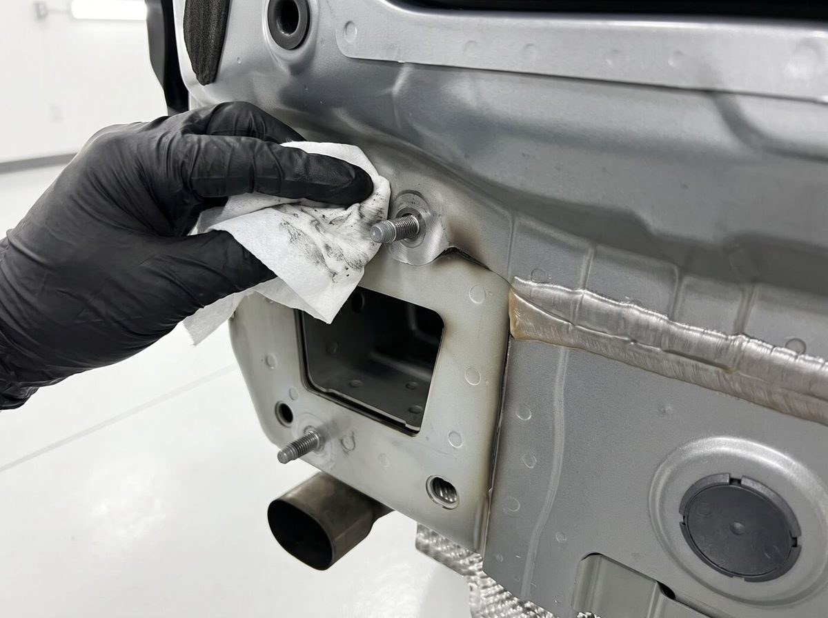 Technicien en atelier préparant le point d'ancrage sur le châssis du véhicule