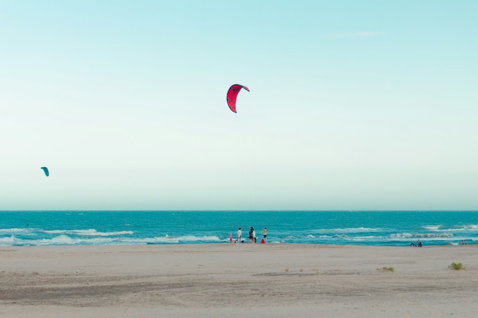 Aile de kitesurf posée sur une plage de sable, prête pour une séance d'initiation